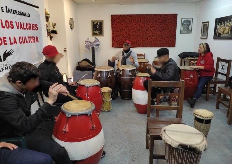 Jóvenes tocando el tambor con representantes de Mundo Afro