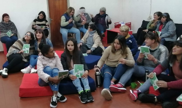 Jóvenes sentados en el piso con la revista