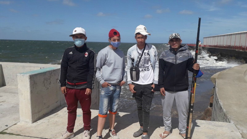 Jóvenes en el muelle con caña de pescar